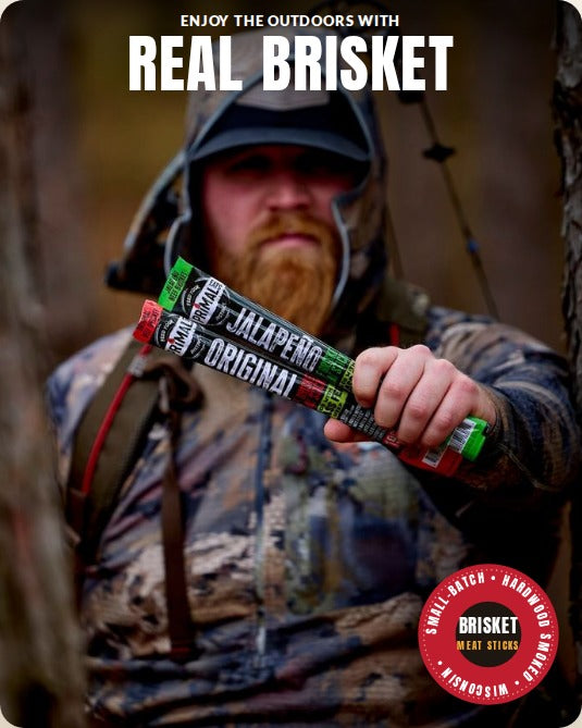 Hunter in camo holding Original and Jalapeño brisket sticks