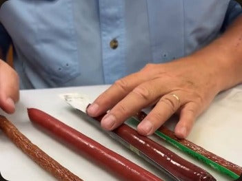 Scott Follett lining up brisket sticks on a cutting board