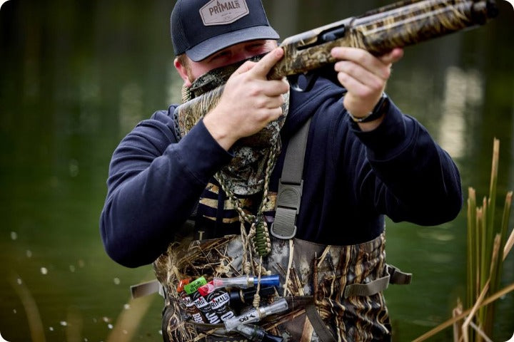 Duck hunter aiming with brisket sticks in his front pocket next to the calls